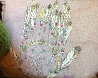 Hand-shaped embroidered decorative pillow or textile with botanical design.