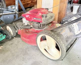 Red lawn mower or outdoor yard equipment in garage.