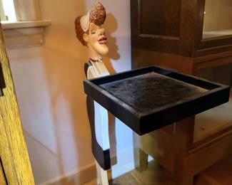 Black pedestal/plant stand with decorative mannequin head display.