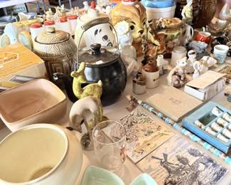 Large tabletop overview loaded with pottery, figurines, glass, animal pieces, tins and unusual small collectibles.