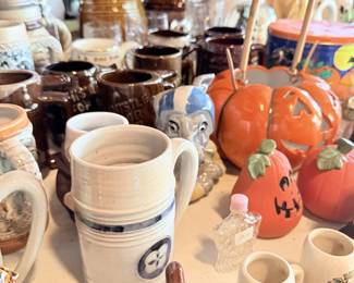 Stoneware mugs, lidded jars, pumpkin pitcher and kitchen pottery grouping.