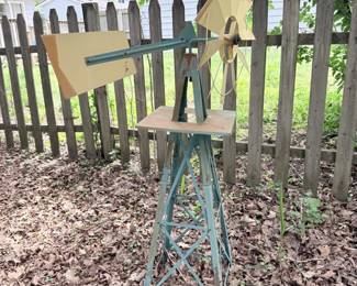 Tall outdoor birdhouse or yard-art stand with rustic blue base.