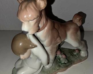 Lladró-style porcelain, a large dog pulling/holding a child by shirt