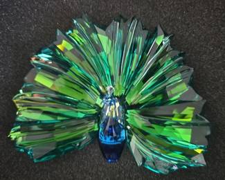 This item is the Swarovski SCS Annual Edition 2015 Peacock Arya (model #5063694), a faceted crystal figurine featuring a prominent fan-shaped tail.
