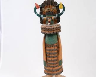  Ted Francis Jr. is a respected Hopi carver listed in Gregory Schaaf’s authoritative reference book, Hopi Katsina, 1600 Artist Biographies. He learned the time-honored craft from his father, Ted Francis Sr., using traditionally harvested cottonwood root and precise wood-burning or painting details.The Figure: This specific piece depicts a Shalako (Cloud ) figure, intricately styled with a tall green feather ornament, horizontal curved horns, a stepped wooden headdress, and detailed layered clothing textured to replicate ceremonial regalia. There is a condition issue with be beak.