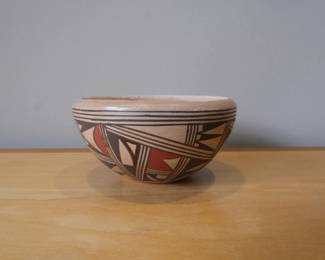 This is a beautifully crafted Hopi-Tewa polychrome pottery bowl by the renowned artist Antoinette Silas (also known as Antoinette Silas Honie).About the Artist & StyleArtistic Heritage: Antoinette comes from an esteemed family of Hopi-Tewa potters from First Mesa on the Hopi Reservation. She learned the traditional craft from her mother, Roberta Youvella Silas.Design Influence: Her distinctive style utilizes complex, tightly-woven geometric compositions. These patterns are heavily inspired by ancient Sikyatki-style pottery shards dating back to the 14th and 15th centuries.Traditional Methods: True to native Hopi techniques, her pieces are painstakingly hand-coiled from local clay, hand-polished, painted with natural mineral or plant pigments (such as wild bee plant), and traditionally fired outdoors.