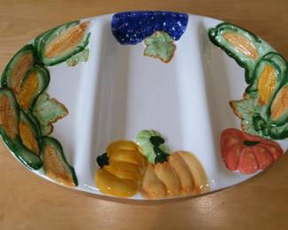 This ceramic majolica serving platter features hand-painted vegetables, including corn and pumpkins.