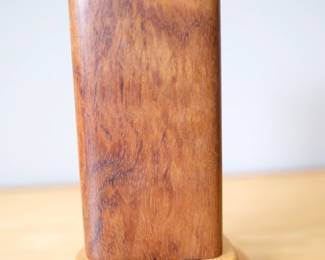 This is an original 2002 version of the Turniton Kaleidoscope by artist Henry Bergeson.Key Differences of the 2002 Edition:Natural Lighting Only: Early editions like this one did not incorporate the later-added integrated circuit board or battery-operated LED system. Instead, it relies entirely on ambient external light passing through the object chamber to illuminate the patterns. Aesthetic Materials: It retains the signature sculptural woodwork using premium hardwoods like bubinga, cherry, or maple, paired with a matching hardwood display base and a satin-smooth finish.