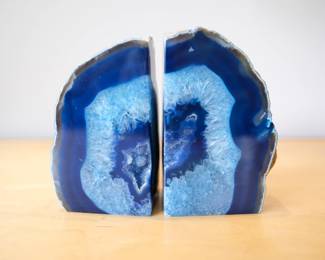 These natural blue agate bookends are cut and polished geode stones often sourced from Brazil to provide a unique, decorative look for shelves.