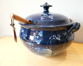 Studio pottery lidded soup tureen, featuring a distinctive blue crystalline drip glaze and a wooden ladle.