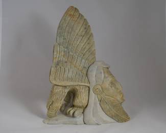 This is a beautiful, authentic piece hand-carved out of multi-toned soapstone by Lori Laforme Thomas, a renowned contemporary Haudenosaunee (Iroquois) artist.Artwork DetailsThe Imagery: Laforme's work frequently blends human figures with highly detailed animal protectors. This particular sculpture highlights a stylized Native chief's profile integrated into the body of an eagle with prominent, layered wings.The Material: It utilizes a multi-tonal soapstone block, contrasting a lighter-colored stone for the facial profile with a deeper, golden-olive hue for the eagle body and wings.Artistic Style: Laforme is celebrated among collectors of contemporary Indigenous art for imbuing his works with intense emotion, refined realism, and deep connections to the land. Note crack at base near eagle beak and minor damage to back side feathers (not shown).