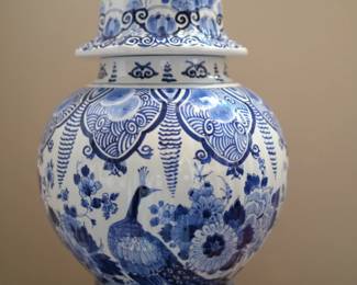 This item is a Royal Delft lidded ginger jar featuring a prominent peacock motif in hand-painted blue and white.Brand: Royal Delft (Porceleyne Fles), established in the Netherlands.Style: Classical Dutch blue and white pottery, often referred to as Delftware or Delft Blue.Motif: Traditional Chinoiserie style featuring a peacock surrounded by flowers, such as peonies.