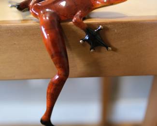 This is the "Hung Over" bronze sculpture by artist Tim Cotterill, also known as "The Frogman".The piece is designed to hang over the edge of a shelf, mantelpiece, or table.It was released in 2004 as part of a limited edition of 5,000 sculptures.The sculpture measures approximately 5 x 6 x 8.75 inches. Note minor condition issues with enamel.