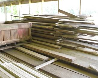 Lot of Rough-Sawn Dimensional Lumber alongside an Antique Wooden Harvest Crate