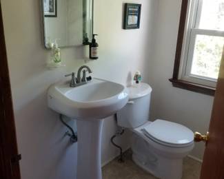 Pedestal sink; mirrored medicine cabinet; toilet