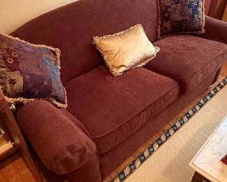Plush Burgundy Sofa with Decorative Pillows and Matching Rug