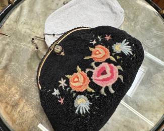A vintage Birks 1940s French beaded and tambour embroidery floral black bag with metal frame and beaded metal chain handle, and a vintage Coblentz (made in Belgium) white beaded clutch purse with rhinestone-accented kiss lock.