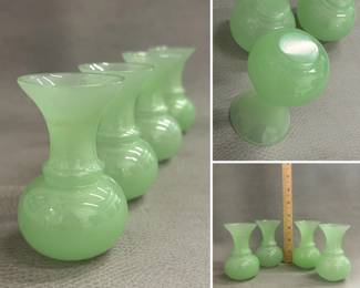 A set of four Peking glass bud vases, pale celadon or spring green, with compressed globe body and long neck ending in a flared rim. Size approximately 3.75 x 2.25 inches.