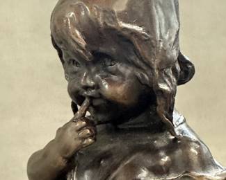 Closeup of the vintage Juan Clara bronze sculpture, 13" tall, titled "Suzette on a Stool," depicting a young girl standing on a stool while holding her shoe; features a dark brown patina and has inscribed signature, foundry initials “LB” and edition number 347 as it was made using lost wax casting method. Very collectible item from Spanish artist Juan Clara (1875-1958).