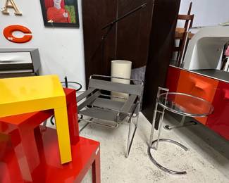 A Midcentury Modern design Wassily-style chair after the design by Marcel Breuer; mid-century modern multi-color plastic tables in white, red, and yellow; a 1983 Mario Arnaboldi “Mira” black floor lamp produced by Programmaluce, Italy; an Eileen Gray-style adjustable table featuring a glass top and a height-adjustable tubular steel frame; a Raymond Loewy DF2000 two-sided, eight-door buffet or room divider cabinet, and a signed painting by outsider artist Dennis Olejarczyk (Muskegon, Michigan), acrylic on wood panel