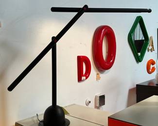 A black table lamp in the style of Mario Arnaboldi's "Mira" lamp.