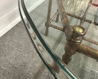 Closeup of the vintage Baker Hollywood Regency era faux bamboo oval coffee table with a removable glass top on an octagonal, eight-legged faux bamboo base with a lacquered finish, 44” W x 31” D x 16” H