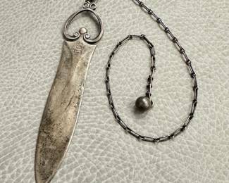 Another view of the Georg Jensen sterling silver dagger-form letter opener with a long chain ending in a small ball weight; stamped with Georg Jensen logo, STERLING DENMARK, and the numbers 254.
