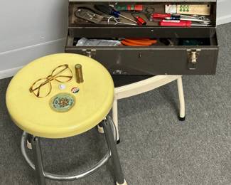 A small yellow-topped metal shop stool, and a vintage Craftsman metal cantilever-style tool box (contains some screwdrivers, an adjustable wrench, pliers, a small scraper, and more)