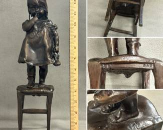 A vintage Juan Clara bronze sculpture, 13" tall, titled "Suzette on a Stool," depicting a young girl standing on a stool while holding her shoe; features a dark brown patina and has inscribed signature, foundry initials “LB” and edition number 347 as it was made using lost wax casting method. Very collectible item from Spanish artist Juan Clara (1875-1958).
