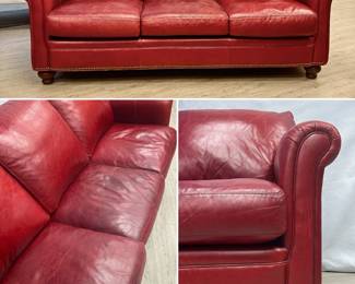 A Bradington-Young three-seat rich red leather sofa with gracefully rolled arms, nailhead trim, and turned mahogany finish wood legs. Made in Hickory, North Carolina. Measures 80"W x 42"D x 35"H.