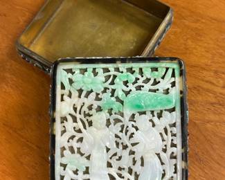 Closer view of the antique Chinese trinket box with top panel of meticulously hand-carved jade inlaid into a frame with enameled precious objects and vases of peonies in relief on hammered side surfaces; underside of lid with inset mirror
