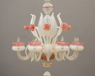 A 1970's Murano "Daffodil" Venetian glass chandelier. Eight arm design in Opalescent and Cranberry glass with Gold leaf detail and twisted arms with alternating floral and foliate stems. Minor wear, some tiny edge flakes on a few leaves. 31" diameter x 32" high overall. ESTIMATE $600-800