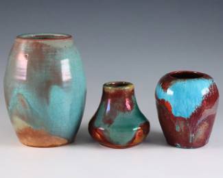 Three small early 20th century Pewabic Pottery vases. Various forms with iridescent glaze in shades of Green, Oxblood, Blue and Gold. Each with impressed circular "Pewabic PP Detroit" marks used c. 1930. Some crazing, miniature baluster vase has two small flakes at rim with painted touch-ups. Up to 3 3/4" high. ESTIMATE $800-1,200