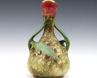A late 19th century Amphora Art Pottery vase. Molded body with two handles and Thistle design, with multi-color decoration and Gilded detail. Impressed "Amphora / Austria" with Crown marks. Some wear, crazing. 9" high. ESTIMATE $200-300