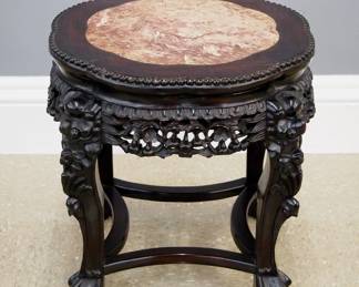 A turn of the century Chinese low side table. Rosewood construction with carved foliate design features a shaped top with marble insert over a carved skirt and four short cabriole legs with mask knees and paw feet with an shaped stretchers. Original finish with some wear, minor damage. 18" diameter x 13" high overall. ESTIMATE $200-300