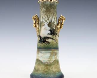 A late 19th century Amphora Art Pottery vase. Molded body with Griffon ring handles, reticulated rim and multi-color landscape decoration with flying birds and Gilded detail. Faintly impressed "Amphora" mark. Minor wear, crazing. 10 3/4" high. ESTIMATE $300-400
