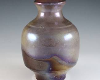 An early 20th century Pewabic Pottery vase. Bulbous form with flared neck and iridescent glaze in shades of Purple, Green and Gold. Impressed circular "Pewabic Detroit" mark. Minor surface wear, 1/4" flake to foot. 5 1/2" high. ESTIMATE $400-600