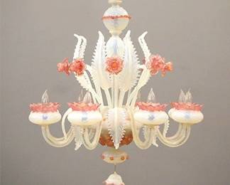 A 1970's Murano "Daffodil" Venetian glass chandelier. Eight arm design in Opalescent and Cranberry glass with Gold leaf detail and twisted arms with alternating floral and foliate stems. Minor wear, some tiny edge flakes on a few leaves. 31" diameter x 32" high overall. ESTIMATE $600-800