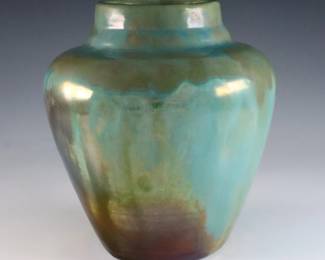 A mid 20th century Ira and Ella Peters for Pewabic Pottery vase. Tapered form with high shoulder and iridescent glaze in shades of Green, Blue and Gold. Incised "Ira" and "Ella" c. 1930-1950. 6" high. Slight surface wear. ESTIMATE $400-600