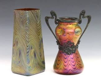 Two turn of the century Bohemian Art Glass vases attributed to Kralik. Iridescent glass bodies in various colors, one with pinched waist, metal fittings and pulled decoration, the other with tapered form and molded decoration. Unmarked. Minor surface wear and fleabites, metal with oxidation. Up to 6 1/2" high. ESTIMATE $200-400
