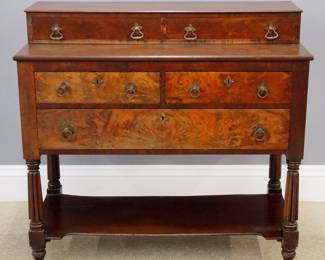 A 19th century American Sheraton Period server. Mahogany construction with Crotch Mahogany drawer fronts features two drawers at the upper section and two smaller drawers above one larger drawer at the lower section, on reeded supports ending in ball feet. Older refinishing with surface wear and fading, replaced hardware. 40 3/4 x 18 1/2 x 38 1/2" high overall. ESTIMATE $300-500