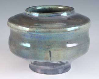 An early 20th century Pewabic Pottery vase. Lobed footed form with iridescent glaze in shades of Blue, Purple and Gold. Impressed circular "Pewabic Detroit" mark, retains the original medallion "Pewabic Detroit" paper label c. 1915-1930. Minor crazing. 5" diameter x 4" high overall. $600-800