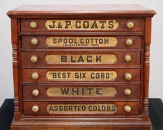 A turn of the century J. & P. Coats Spool Cabinet. Walnut construction features six labeled dovetailed drawers with brass knobs flanked by pilasters at either side along with an advertising panel verso featuring a large spool of thread. Old refinish with some wear, some chips and separation, no dividers. 26 x 19 1/4 x 22 1/2" high overall. ESTIMATE $400-600