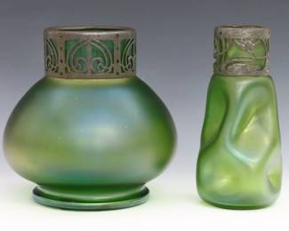 Two turn of the century Bohemian Art Glass vases attributed to Loetz. Green bulbous and dimpled Green glass bodies with Iridescent finish and pierced metal collars. Minor surface wear and fleabites, metal with oxidation. Up to 6 1/2" high. ESTIMATE $100-200