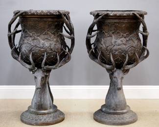 A pair of late 20th century Bronze garden urns. Cast with a shaped body with Elk in a landscape and full Elk head supports on a circular pedestal base with acanthus leaf design. Outdoor patina with wear, one repaired antler. 22 x 27 x 47" high overall. ESTIMATE $800-1,200