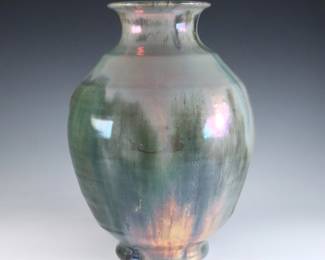 An early 20th century Pewabic Pottery vase. Baluster form with stepped shoulder and iridescent glaze in shades of Green, Purple and Gold. Faintly impressed circular "Pewabic Detroit" mark. Crazing, particularly at raised protrusions at the body from production, some surface wear, a few burst air bubbles. 9 1/4" high. ESTIMATE $1,500-2,500
