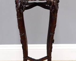 A turn of the century Chinese plant stand. Rosewood construction with carved foliate design features a shaped top with marble insert over a carved skirt and four tall cabriole legs with an "H" stretcher. Original finish with some wear, minor damage. 36 1/2" high. ESTIMATE $200-300
