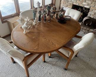 Oak dining table with one leaf (shown) and four chairs.