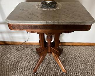Antique Eastlake table with marble top and wheels.