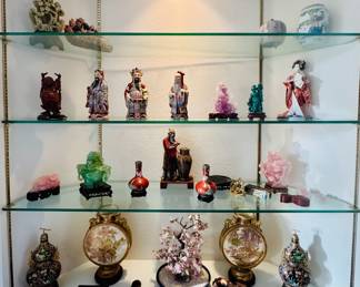 curio cabinet displays a collection of Asian collectibles, including figurines, vases, and decorative items.